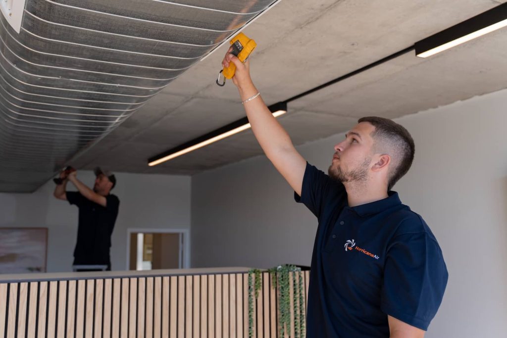 guy checking ducted air con after installing it