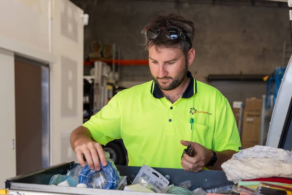 fridge technician getting tools out to fix fridge
