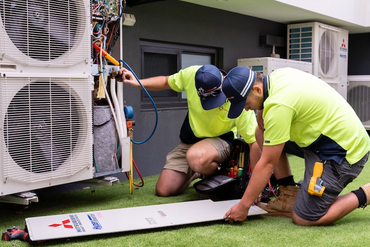 hurricane air con technicians installing a mitsubishi electrical air con