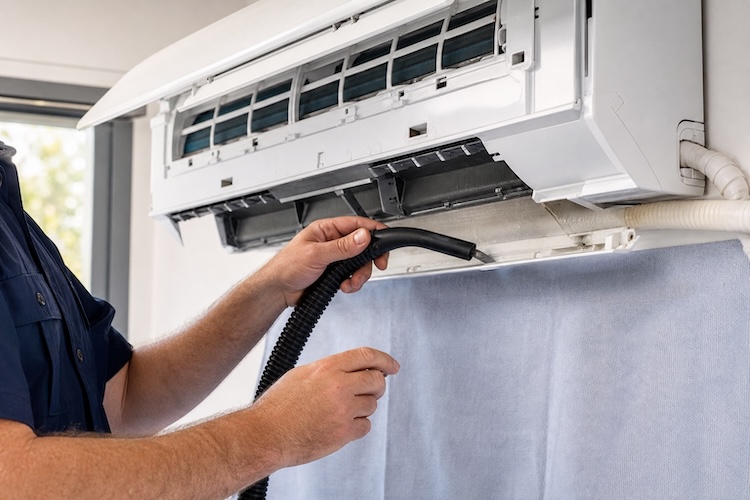 technician fixing leaking ac