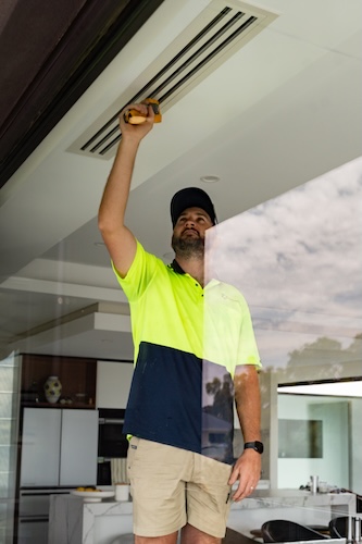 air con expert checking air con is blowing cool air